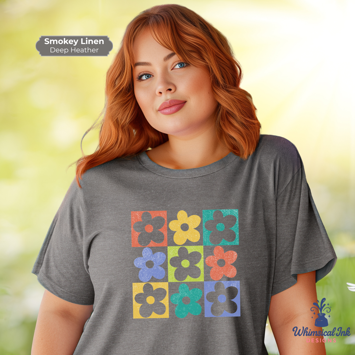 Woman wearing a gray t-shirt with colorful flower design, standing outdoors with a blurred background.