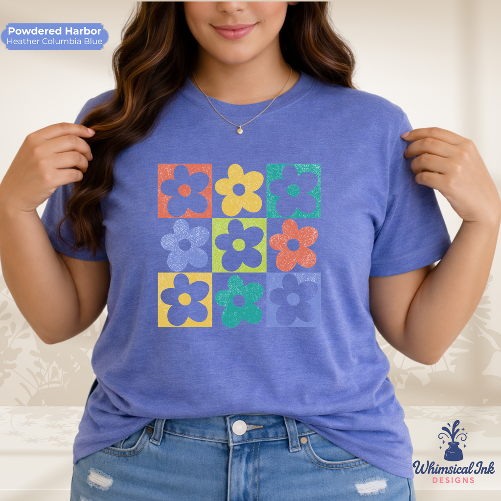 Person wearing a blue t-shirt with colorful flower patterns, standing against a neutral background.