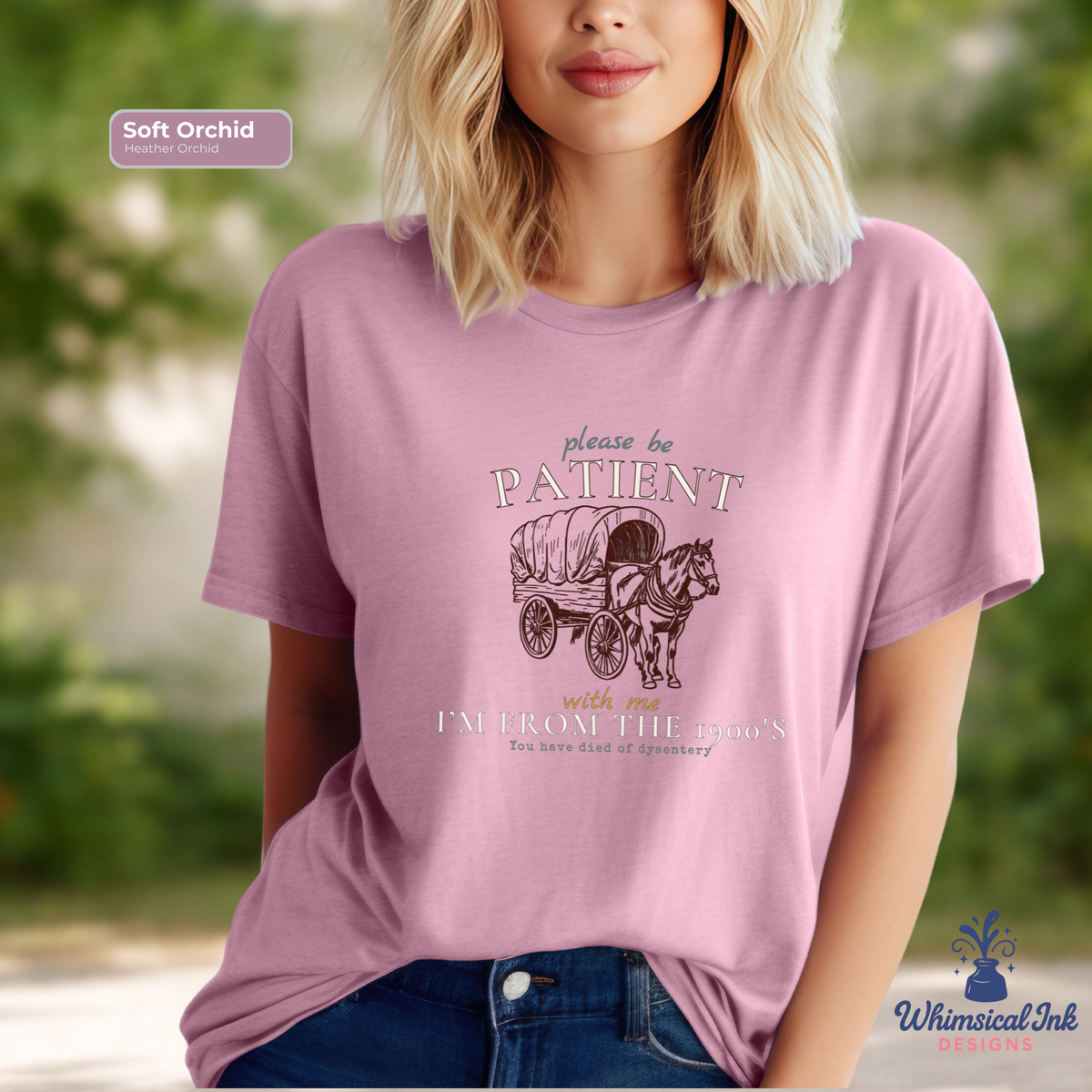 Person wearing a pink t-shirt with a graphic and text, standing outdoors.