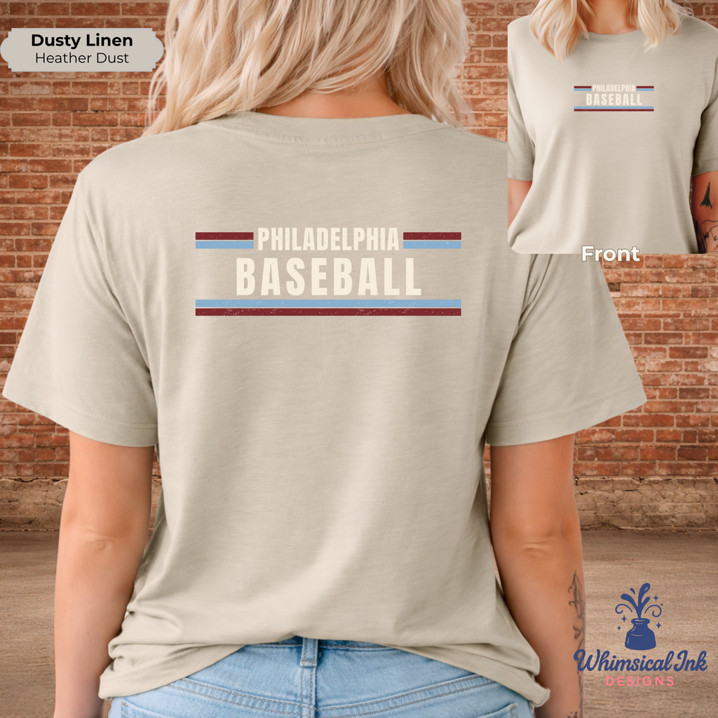 Person wearing a beige t-shirt with 'Philadelphia Baseball' text and colorful stripes, standing against a brick wall.