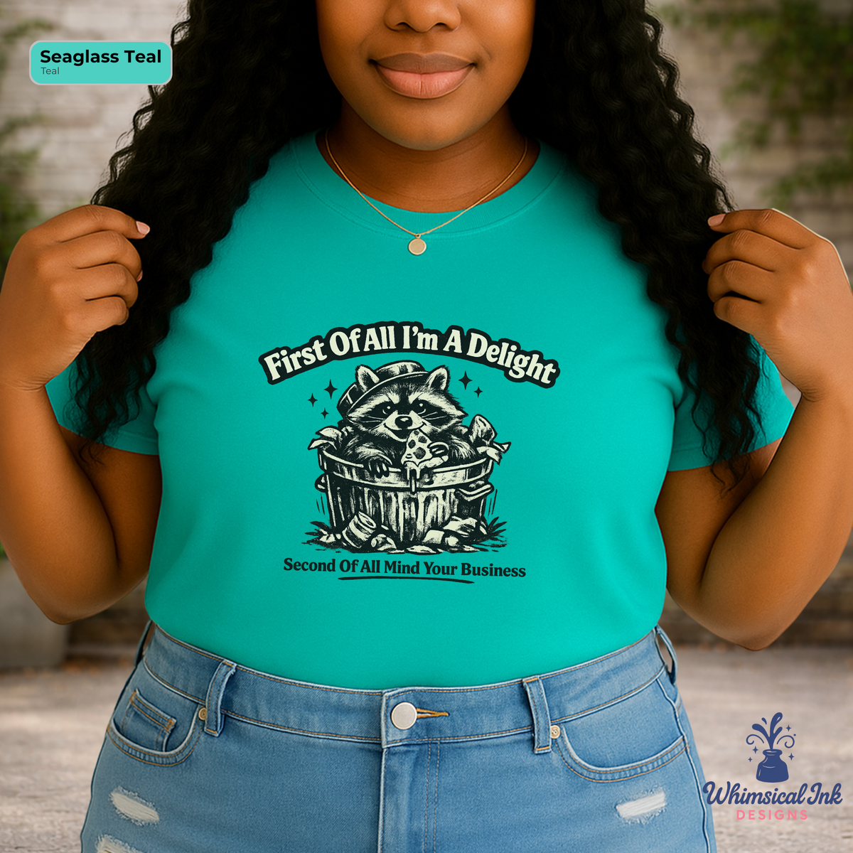 Person wearing a teal t-shirt with a graphic and text, standing outdoors.