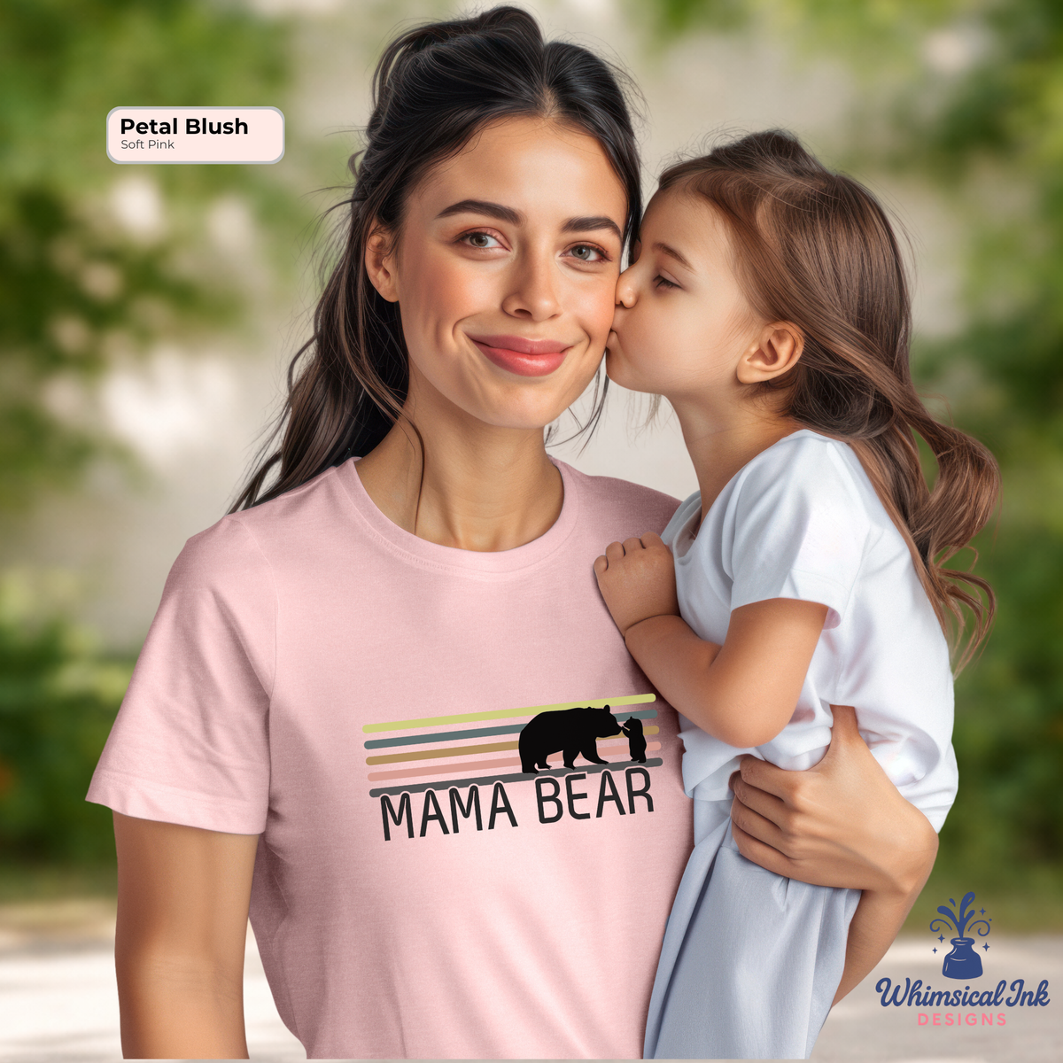 Woman wearing a 'Mama Bear' t-shirt with a child in front of a blurred green background