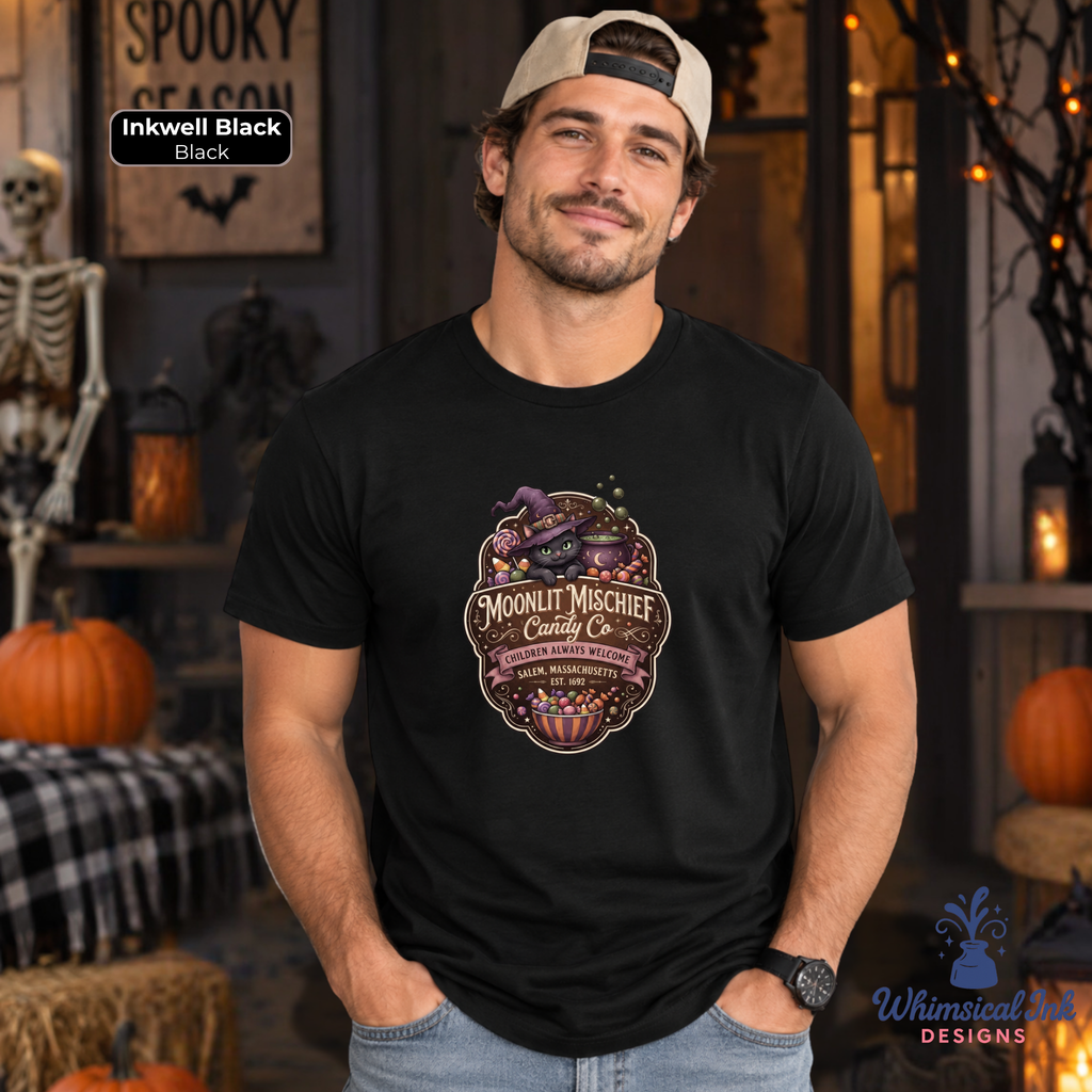A man wearing a black t-shirt with a 'Moonlit Mischief' Halloween graphic, standing in a spooky, decorated room with pumpkins and a skeleton.