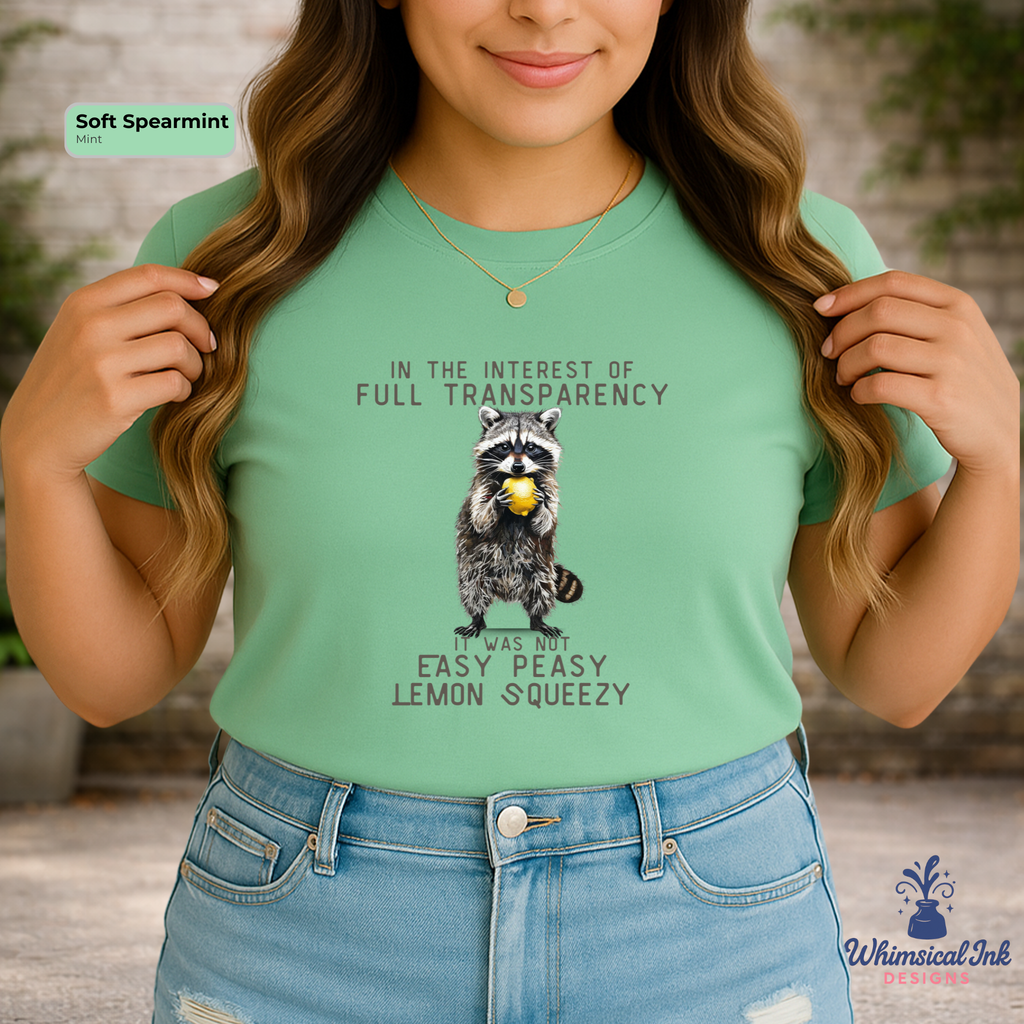 Person wearing a green t-shirt with a raccoon graphic and text, standing outdoors.