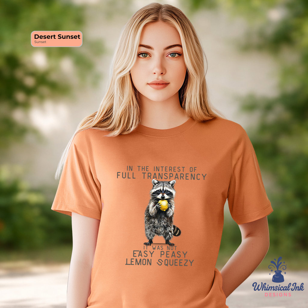 Person wearing an orange t-shirt with a raccoon graphic and text, standing outdoors.