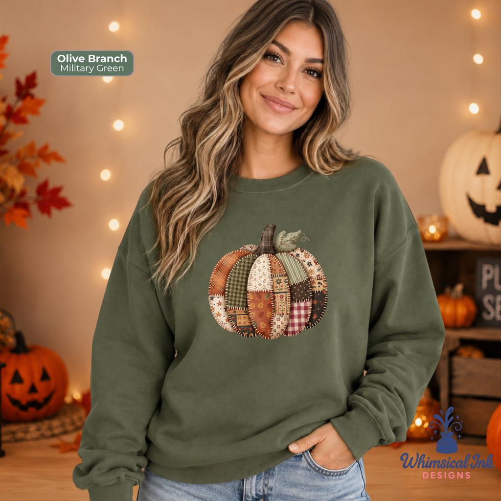 A woman wearing an olive branch sweatshirt with a patchwork pumpkin design on the front, posed in a cozy autumn-themed room with string lights and pumpkins.