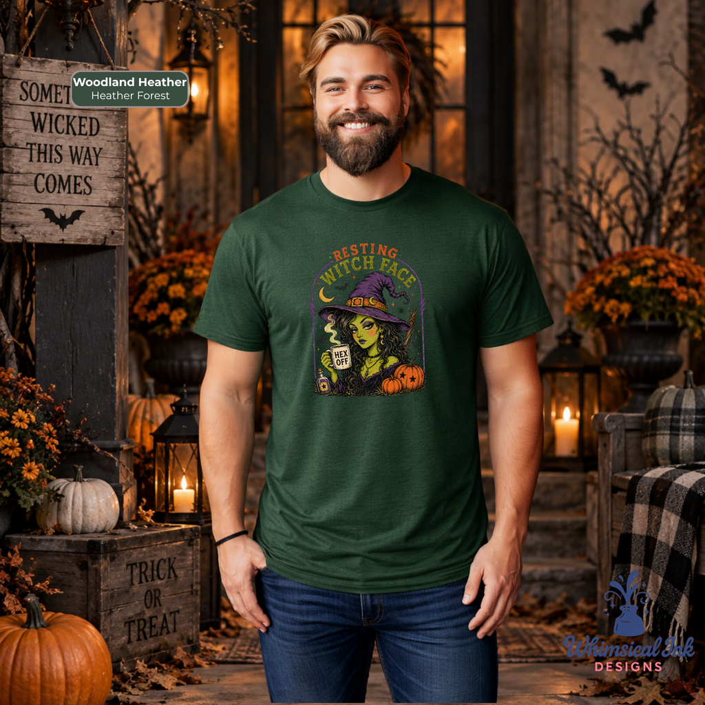 A man wearing a forest green graphic t-shirt with a Halloween witch design, standing in a cozy, warmly lit autumn-themed room decorated with pumpkins, lanterns, and fall foliage.