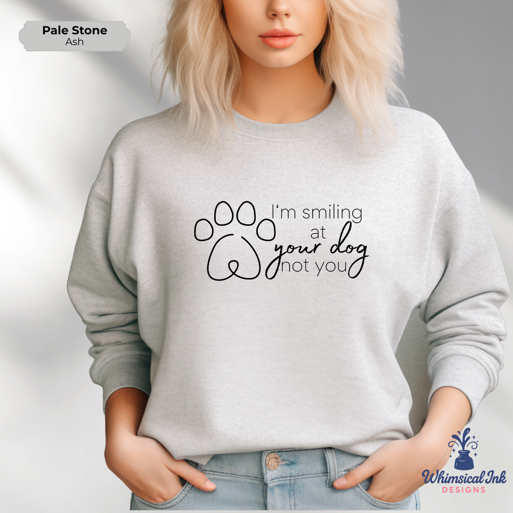 Person wearing a gray sweatshirt with a paw print design and text, standing against a plain background.