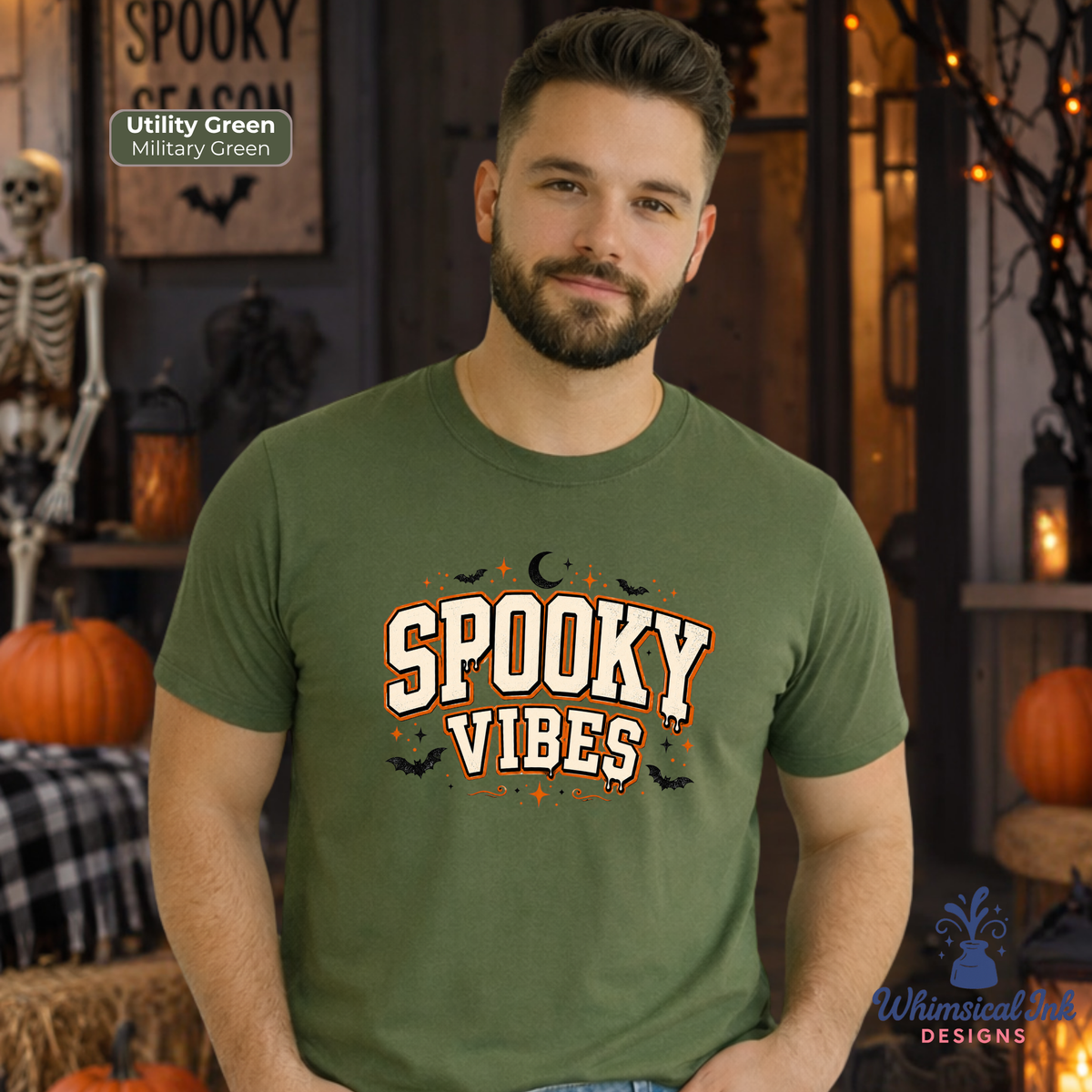 A man wearing a military green t-shirt with a 'Spooky Vibes' graphic printed on the front, set against a Halloween-themed background with pumpkins and a skeleton.